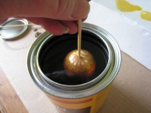 Dunk the egg into the can of varnish